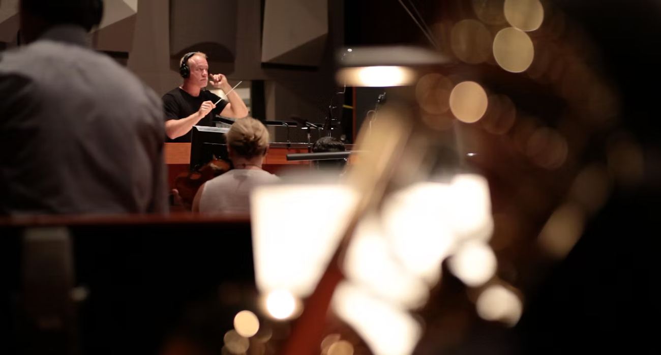 A composer conducts a scoring session